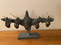 Front view of sculpture showing five hanging figures