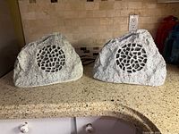 Front view of both rock speakers showing grilles and finish