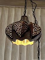 Lamp illuminated to show perforated pattern and chain