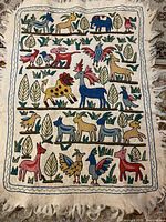 Full view of embroidered wall hanging with animal and bird motifs
