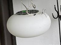 Side view of pendant showing frosted glass elliptical shade, chrome canopy and suspension cables