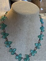 Full view of teal and brown glass bead necklace on bust