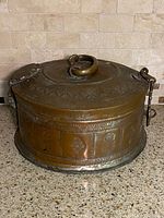 Container with lid closed showing overall form, engravings, side latch