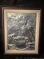 Full view of framed hammered metal floral relief