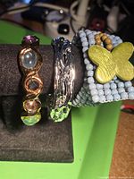 Three assorted bracelets displayed on stand
