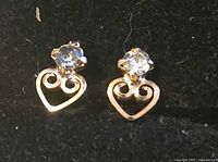 front view of both gold heart earrings showing stones and open hearts