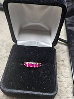 Ring in open box showing five pink stones