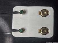 Front view of stud earrings and backs in holder