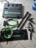 All components laid out: base board, bands, bar segments, grips, straps, carry bag