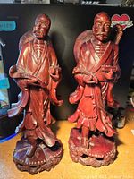 Front view of both red wood scholar statues
