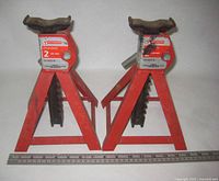 Full view of both red Motomaster axle stands with ruler for scale