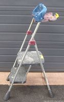 Side view of folding Cosco 2-step ladder with paint tray attached