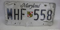 Front of Maryland plate showing number, shield, wear, bend