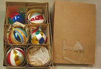 Closed cardboard box and open box with five glass ornaments in dividers