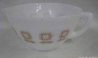 Side view of milk glass mixing bowl showing Sunflower pattern and handle