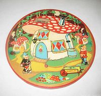 Front view of circular wooden puzzle showing graphic scene and missing roof piece