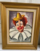 Front view of oil clown painting in gold-tone frame