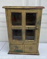 Front view of cabinet showing four-pane glass door and two drawers