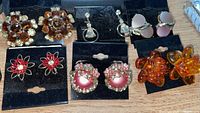 All six pairs of vintage clip-on earrings displayed on cards