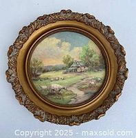 Front view of round landscape painting in ornate frame
