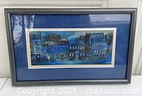Front view of modern blue cityscape print in gray frame with blue mat