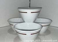Four stacked white Corning bowls showing brown band
