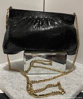 front view of black metal mesh purse with gold chain