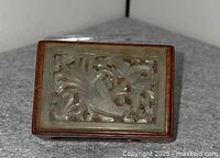 Top view showing carved nephrite jade plaque with bird and floral motif set into rosewood lid
