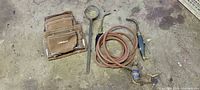 Overview of all items: Kobalt pouch, cast iron ladle, two torch handles, coiled hose with regulator