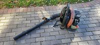 Full view of Echo backpack blower with hose and nozzle on paved surface