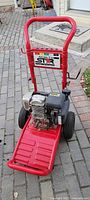 Front view of red North Star pressure washer cart with Honda GC190 engine on paved surface