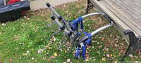 Bike rack fully opened showing three cradle arms and blue straps