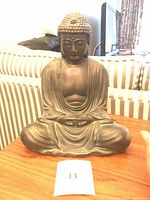 Front view of metal seated Buddha sculpture on a table