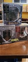 Stacked view showing Return of the King and Fellowship of the Ring gift sets in sealed boxes