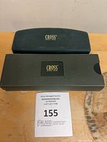 Closed Cross clamshell case and separate outer sleeve on table