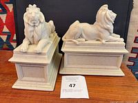 Front view of both lion bookends on plinths