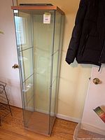 Full view of IKEA Detolf glass cabinet standing upright