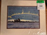 Front view of signed Northern Lights print in mat and plastic wrap with lot tag