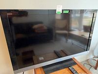 Front view of Sony Bravia TV on stand with remote visible