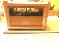 Front view of wooden chime box with ruler for scale