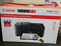 Sealed retail box showing Canon Pixma TR4522 printer image and included ink cartridges