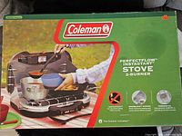 Front of retail box showing Coleman PerfectFlow InstaStart 2-Burner Stove