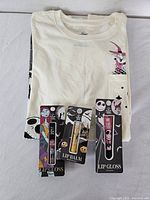 Folded T-shirt with three packaged lip care items on top
