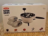Front of retail box showing Oxo Good Grips Food Mill and three disks