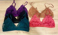 All five lace bralettes laid out showing colours and styles