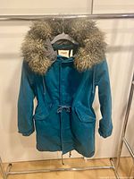 Front view of teal Aritzia TNA parka with faux fur hood