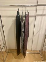 Four Wilfred garments hanging on rack