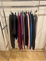 Rack showing nine assorted sweaters on hangers