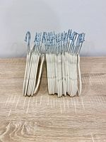 Front view of grouped white velvet baby hangers standing upright