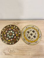 Both brass Meenakari wall plates side by side